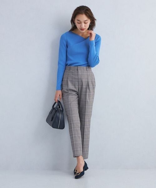 グレーのテーパードパンツをはいた女性