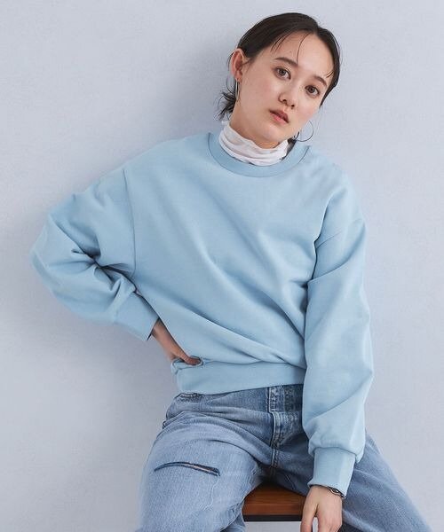 ライトブルーのスウェットを着用している女性