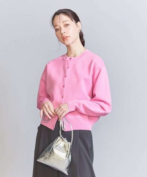 ピンクのカーディガンを着用している女性