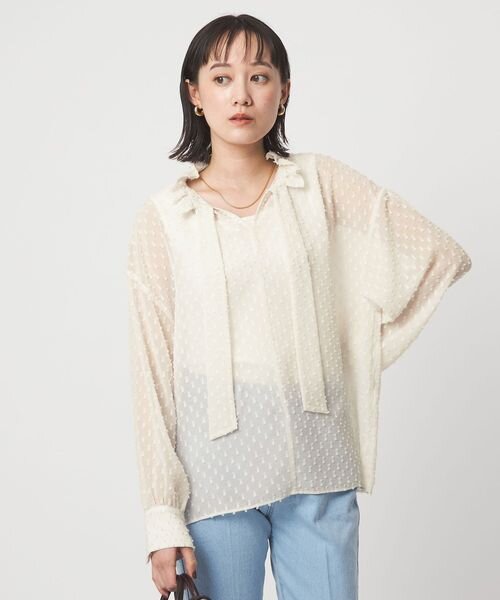 シアー感のあるブラウスを着た女性