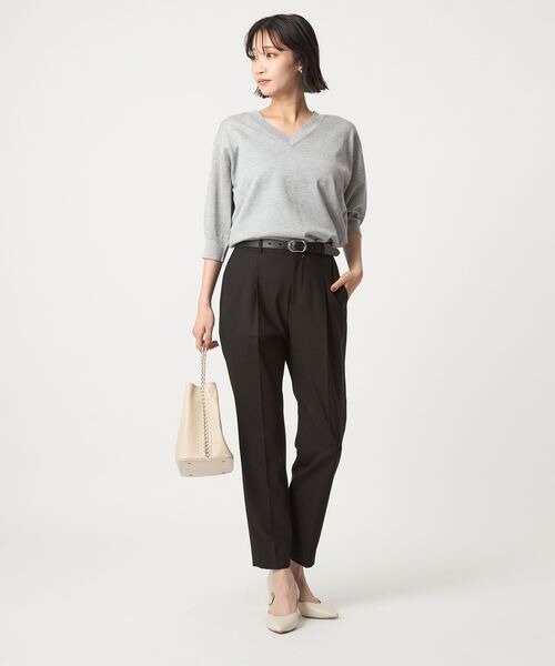 黒のテーパードパンツを穿いた女性