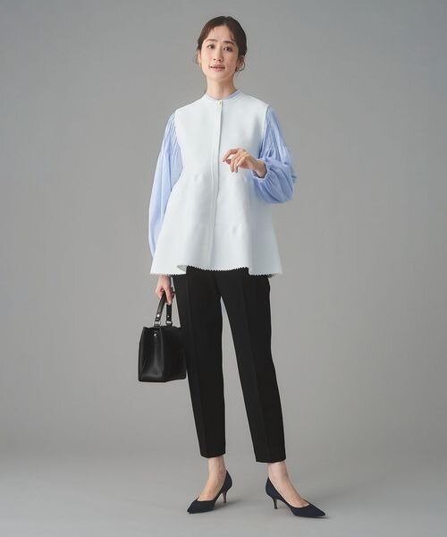 ふんわりとしたベストに細身の黒パンツをあわせた着こなし