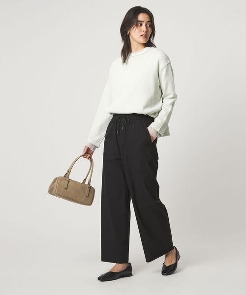 黒パンツに白のトップスをあわせた着こなし