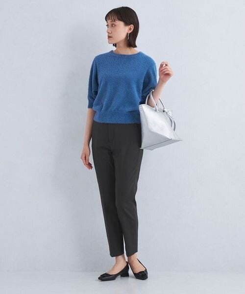 黒パンツにブルーのトップスをあわせた着こなし