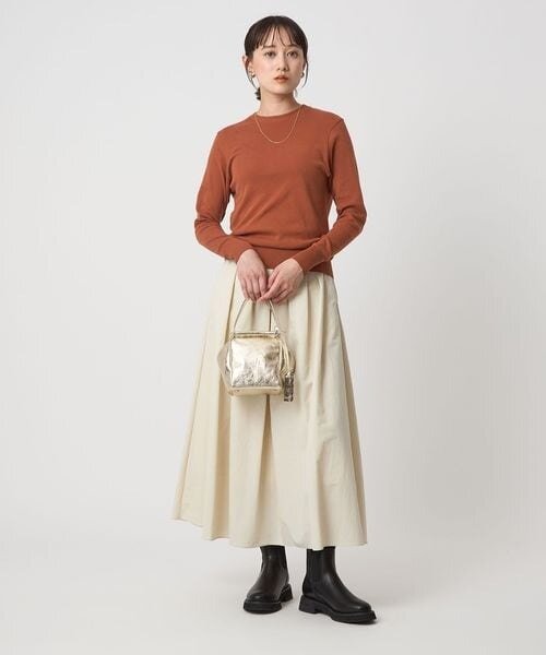 キャメルのロングスリーブTシャツを着た女性