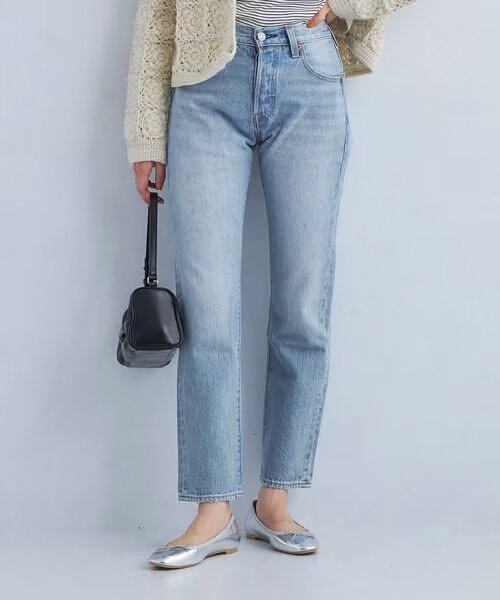 クロップド丈デニムパンツにフラットバレエシューズをあわせた女性