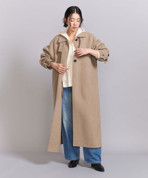 パーカーとコートを重ね着した女性