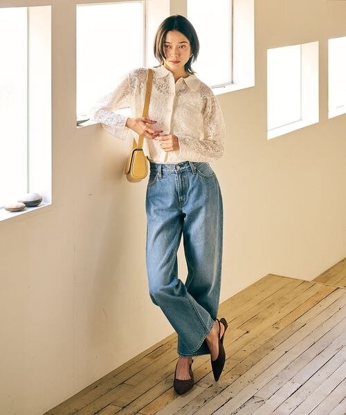 ライトブルーのデニムパンツを着用した女性