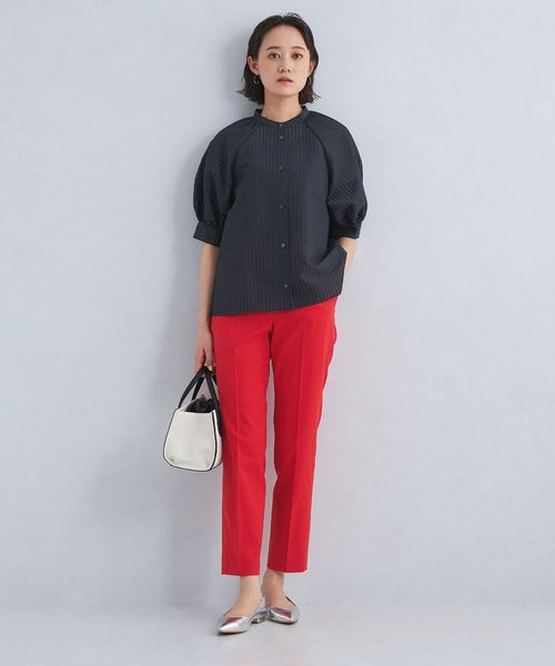 黒のトップスに赤のパンツを着用した女性