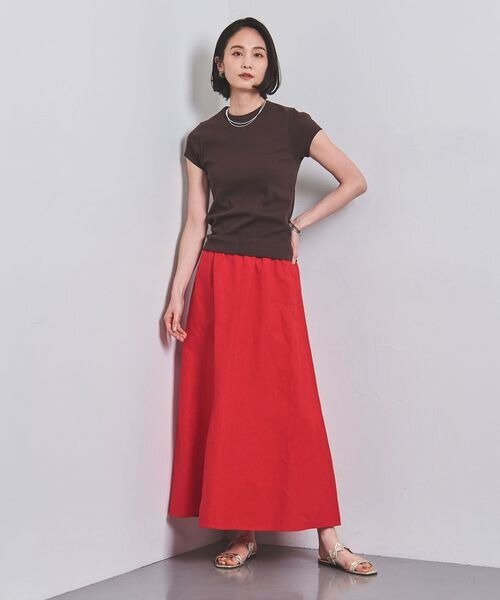 赤のスカート×ブラウンのカットソーを着用した女性