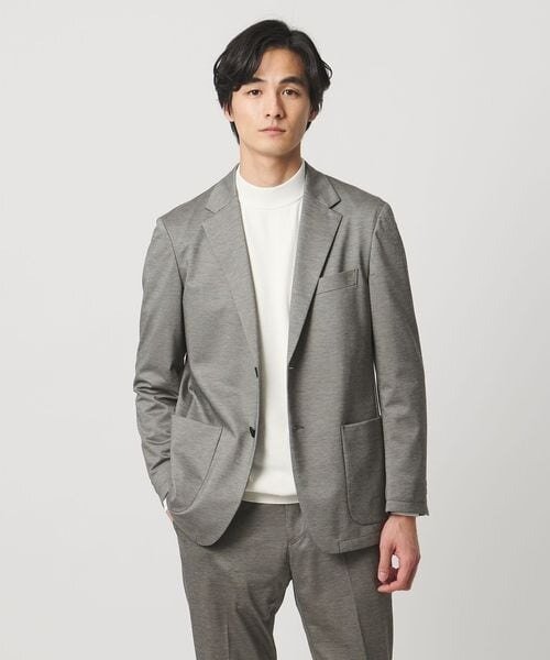 ミドルグレーのジャケットをカジュアルに着る男性