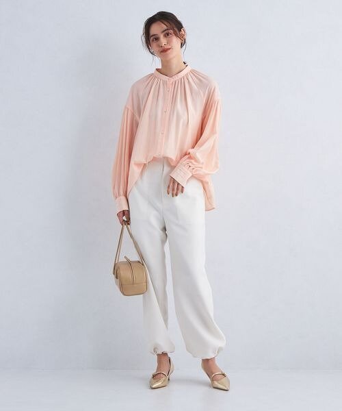 ライトピンクのブラウスを着用した女性