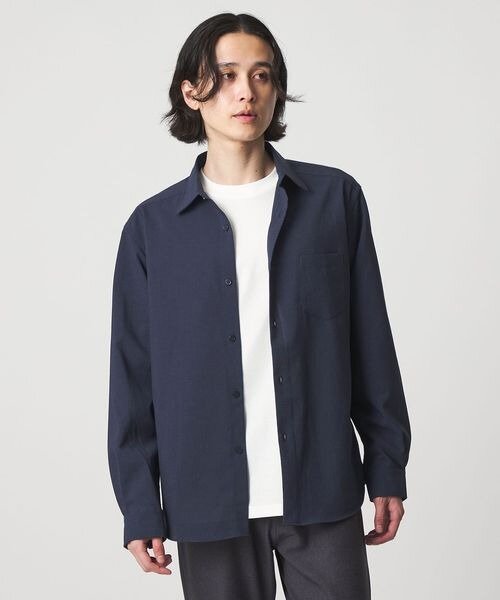 ネイビーシャツを羽織として着る男性