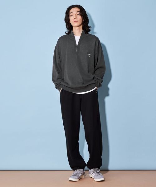 グレーのトップスを着た男性