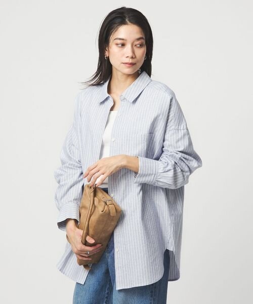 オーバーサイズのストライプシャツを着た女性