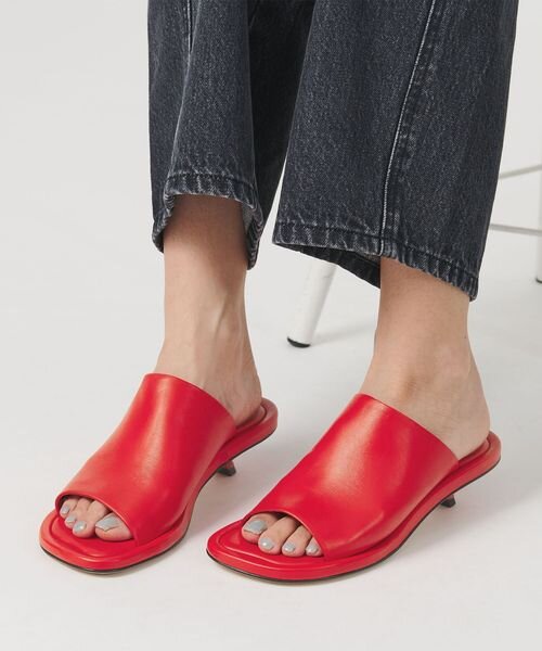 レッドのミュールを履いた女性
