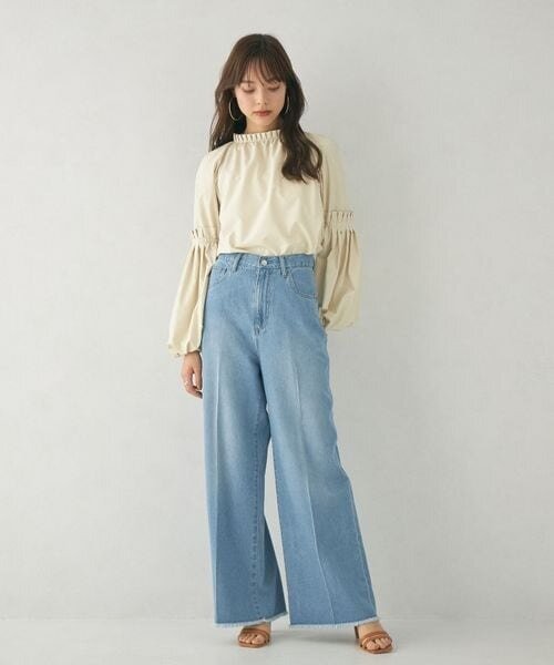白のブラウス×デニムパンツコーデの女性