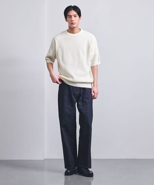 白のニットを着た男性