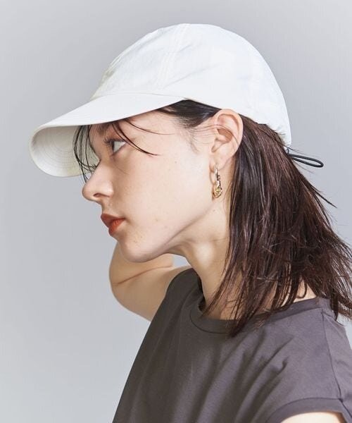 アクセサリーをつけたミディアム×キャップスタイルの女性