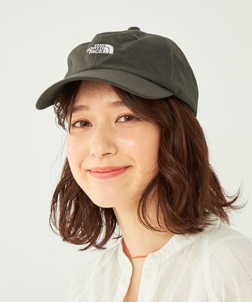 前髪を分けてキャップを被った女性