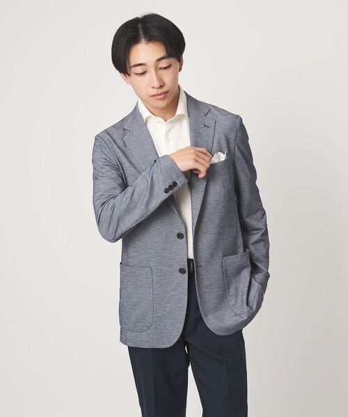 ジャケットのポケットにハンカチを入れている男性