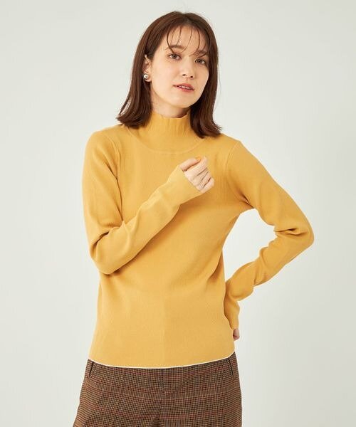 マスタードのニットを着た女性