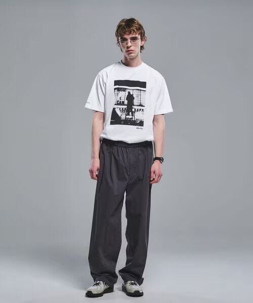 白のプリントTシャツと黒パンツのコーデ