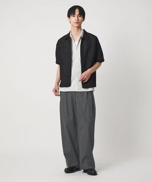 白黒ストライプシャツとグレーパンツのコーデ