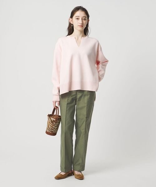 ライトピンクのトップスとカーキのパンツのコーデ