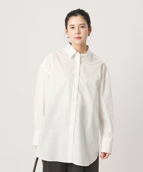 オーバーサイズの白シャツを着た女性