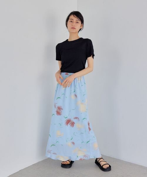 水色のスカートに黒のニットをあわせた女性
