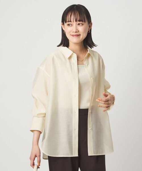 長袖シャツを羽織る女性