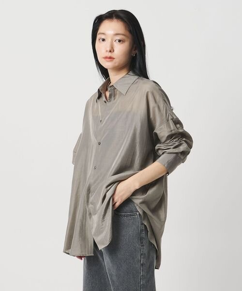 モカカラーのシアーシャツを着た女性