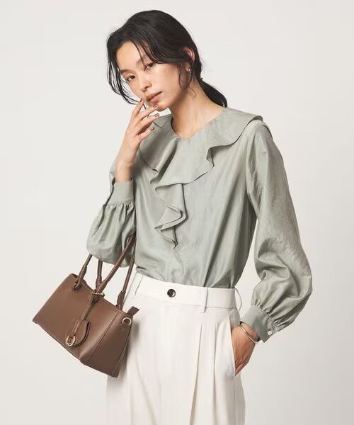 ライムカラーのブラウスを着た女性