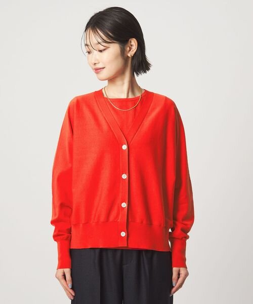 オレンジがかった赤の服を着た女性