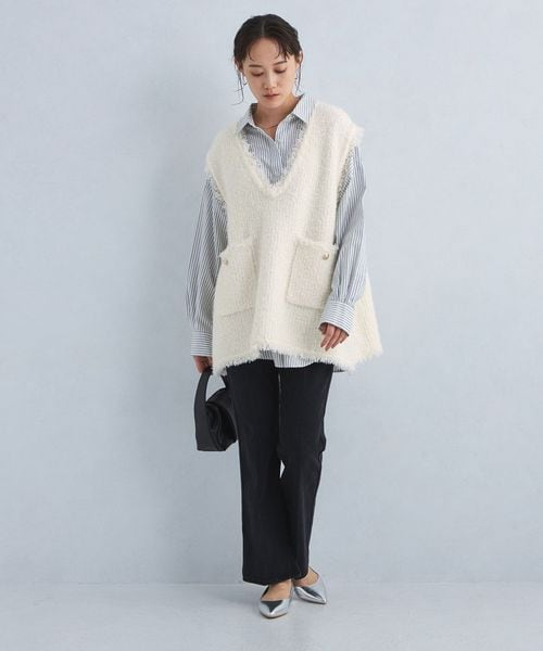 ゆったりめのニットベストとスリムパンツを着た女性