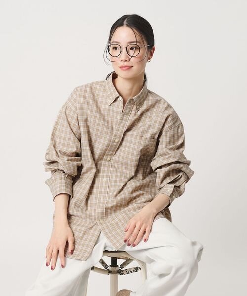 ゆったりしたサイズのチェックシャツを着用する女性