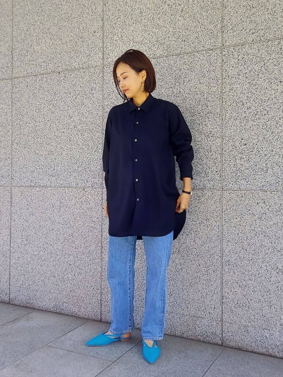 ターコイズブルーのフラットシューズを履いた女性