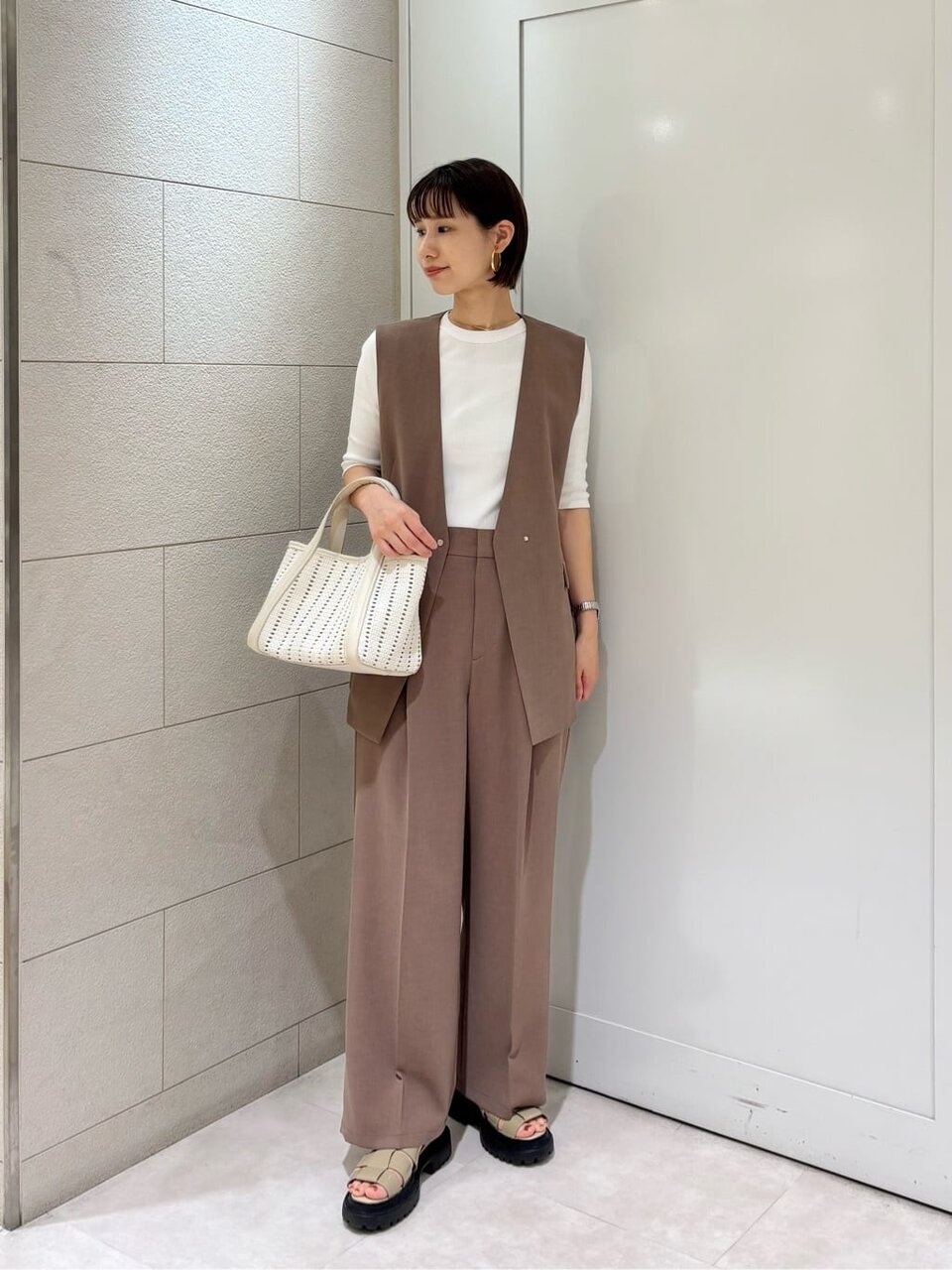 モカカラーのジレを着た女性