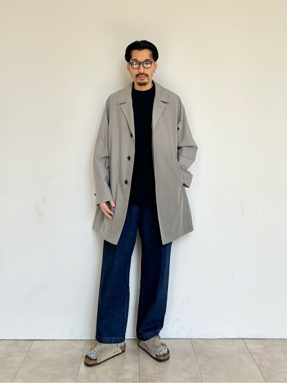 テーラードジャケットとブラックデニムを着た男性