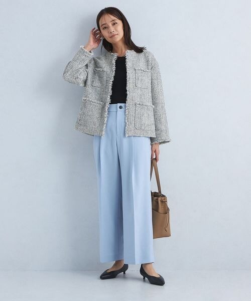 ジャケットにライトブルーのパンツをあわせた女性