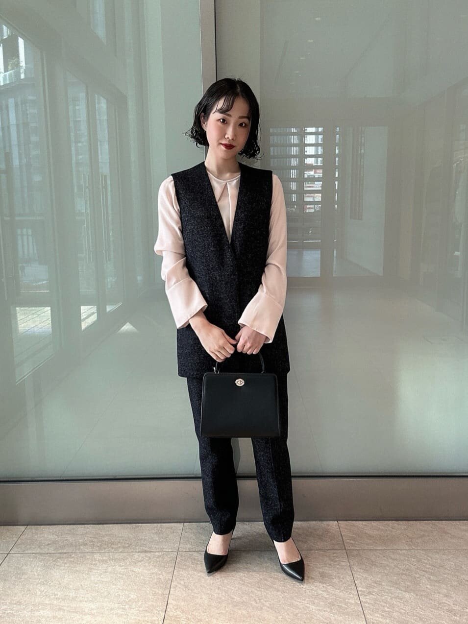ツイードベスト×パンツのセットアップを着た女性