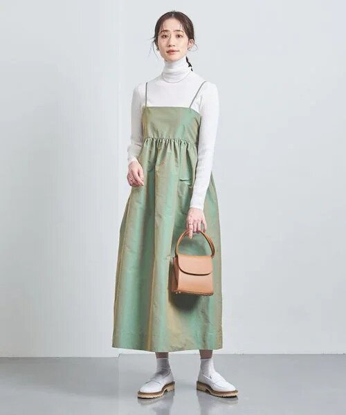 バッグとキャミワンピースを身に着けた女性