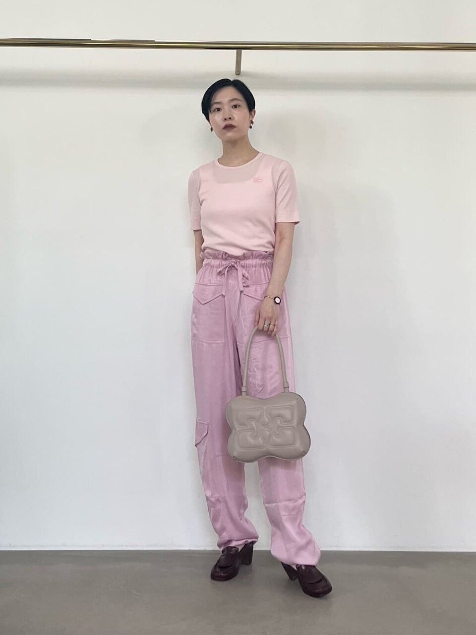 ライトピンクのパンツ×ロゴニットのコーデ