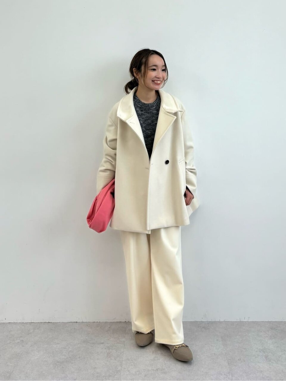 スリムパンツとピンクのミュールを履いた女性