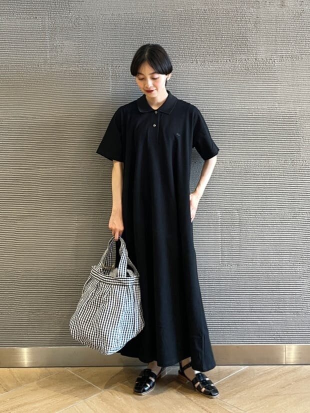 黒ワンピースとチェック柄バッグのコーデ