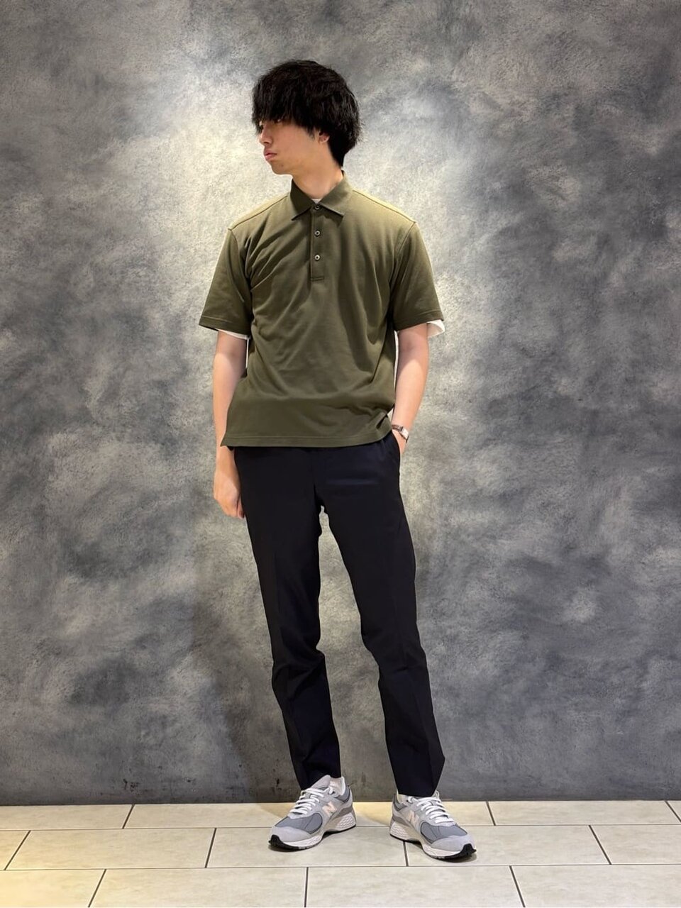 カーキのポロシャツ×黒のスラックスのコーデ