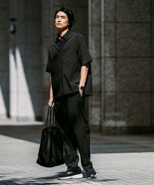 黒のワイドパンツをはいている男性
