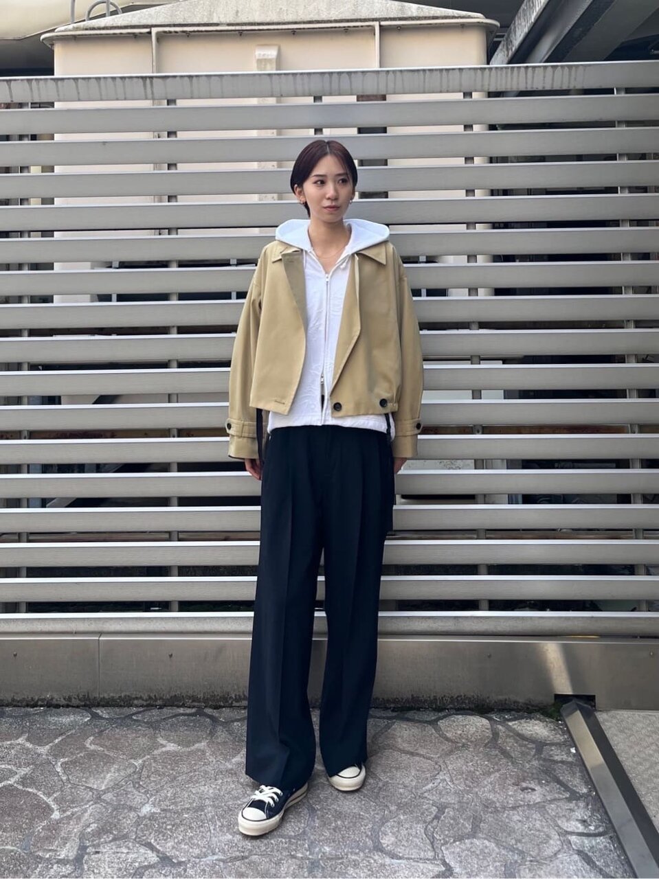 アウターの下にパーカーを着た女性