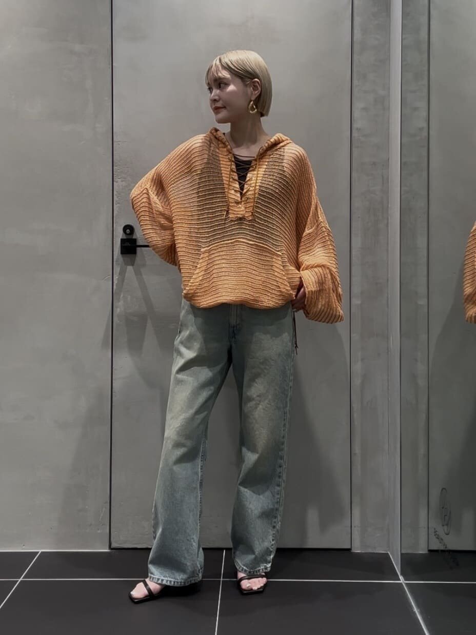 メッシュトップスとデニムを着た女性